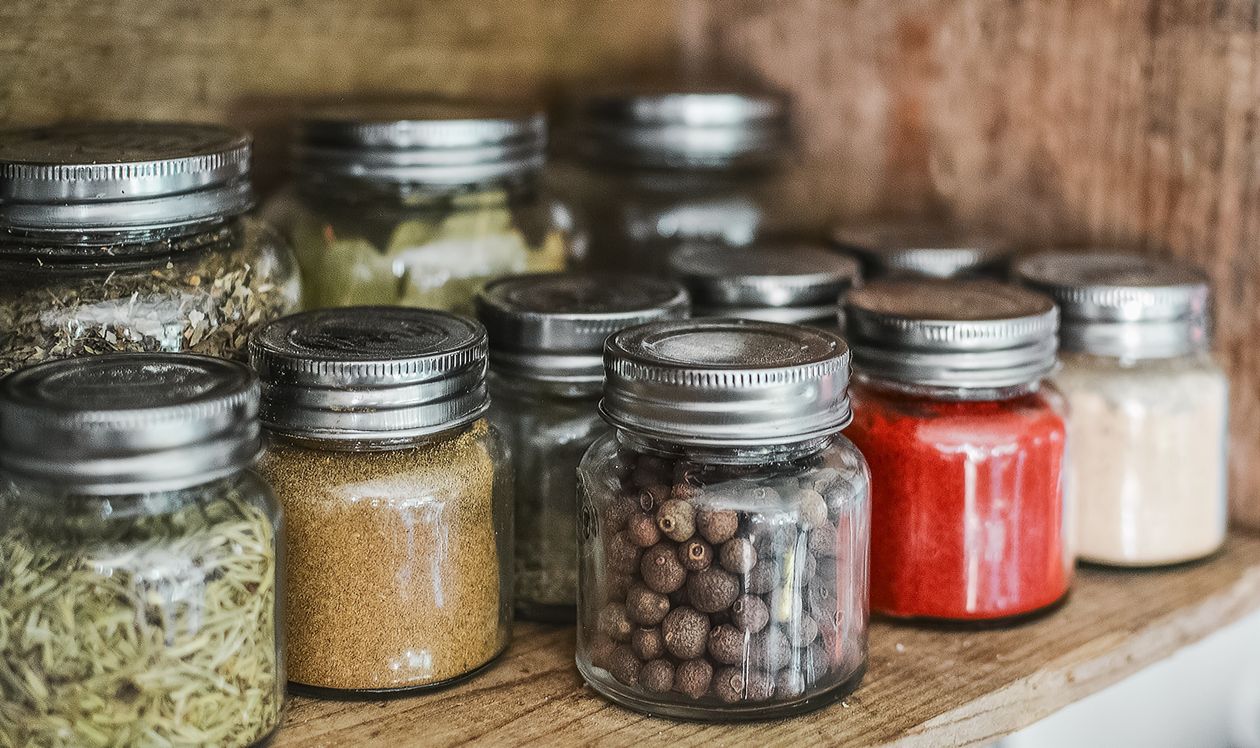 Assorted spice bottles on kitchen shelf – checking expiration dates on seasonings